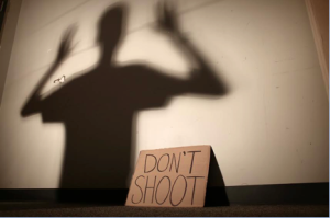 Student uses the “Don’t Shoot” stance used by protesters in Ferguson. People from across the nation travelled to Ferguson to take part in the protests that lasted 16 days this past August.
