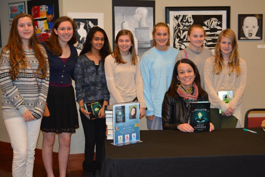 Eighth graders Laura Beard, Maria Sallee, Surabhi Singh, Grace Higley, Snowden Farnsworth, Caroline Swaim, and Elizabeth Crane (left to right) pose with Ally Condie for a picture after her presentation. Many students chatted with Condie and had their copies of her novels signed.
