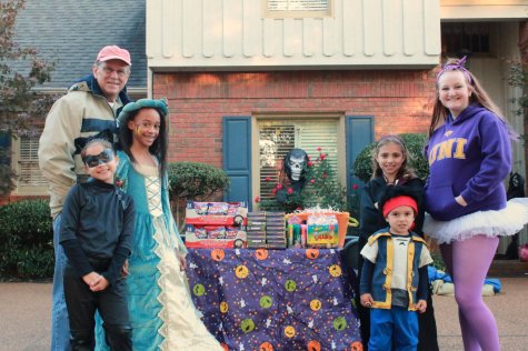 Mr. Williams poses next to his candy table with his grandchildren and their friends. The kids then later went trick-or-treating in their costumes.