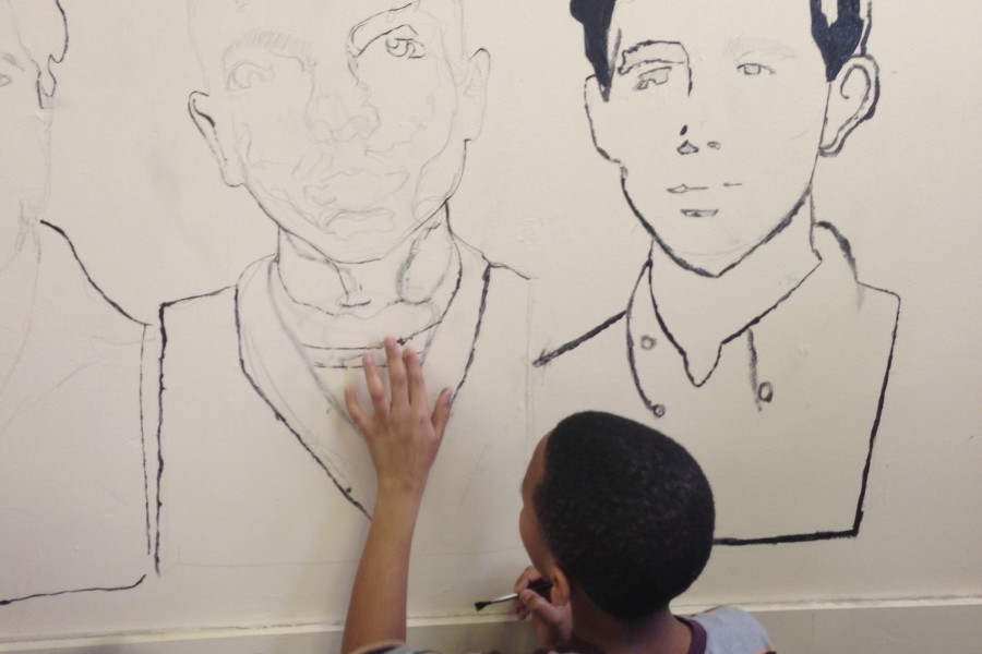 A St. Georges student helps to paint a mural of historical figures that stood up for racism during MLK Day ON. Icons that were painted at the Memphis Academy of Health Sciences included Nelson Mandela and three freedom fighters who took a stand in Selma, Ala.