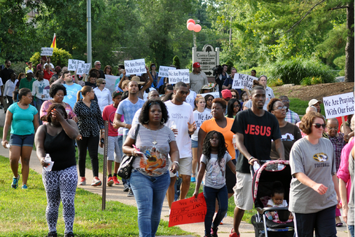 Citizens of Ferguson peacefully protest the cause of death for black teenager, Mike Brown.  Protests continued intermittently between the time of the shooting and Wilson’s verdict.