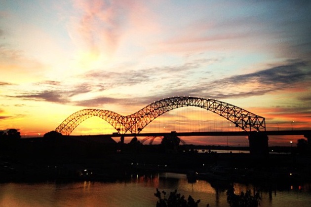 The Memphis Bridges silhouette stands out against a colorful sunset. The bridge is one of the most recognizable features of Memphis.