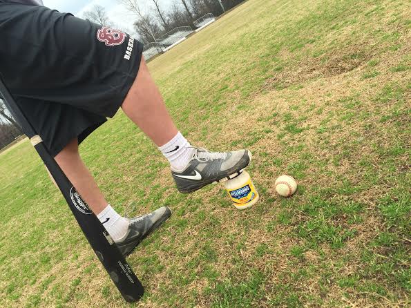 Senior Jack Glosson stands with his mayonnaise before a game. The team has sacrificed mayonnaise to the baseball gods in order to bring them luck.