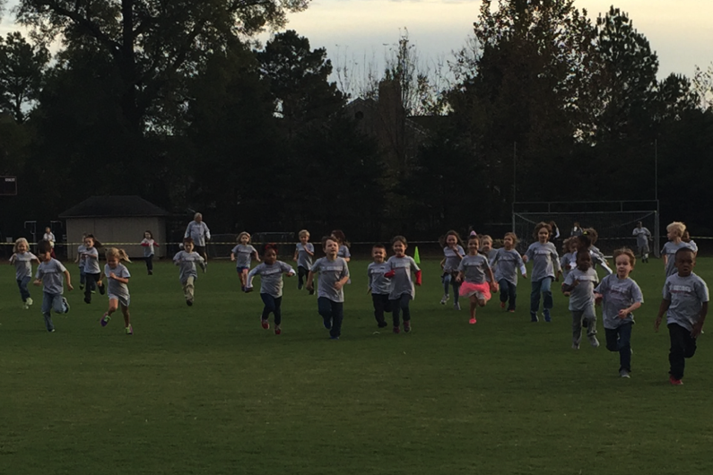 Junior-kindergarten students race across the practice field. All elementary students participated in various distance races held all over the Collierville campus. 
