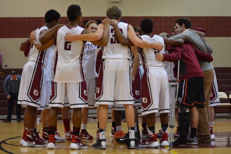 St. George’s varsity basketball forms a huddle to discuss their game plan during a game against ECS on Dec. 9. The Gryphons won state last year and look to do it again.