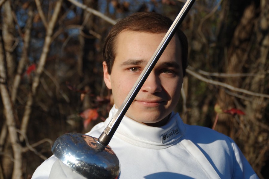 Senior Alex Merino holds his sword across his face. Merino and freshman Aiden Tanzer have started to reinvigorate a new wave of fencers at St. George’s.