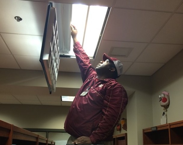 Mr. Ricky fixes a lightbulb in the library. Mr. Ricky has been responsible for much of the maintenance that is needed within the school for two years. 