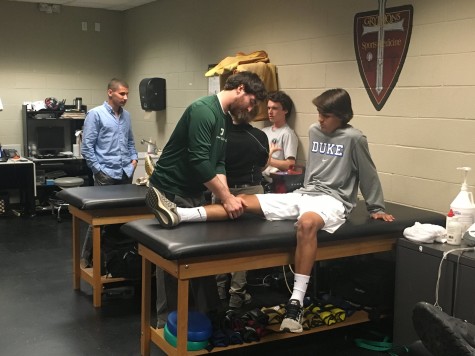 Athletic Trainer Mr. Garrett Cole evaluates sophomore Lathan Spadafora’s knee. Spadafora was one of the dozens of students that visited the trainer last week.