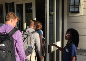 Sixth grader Erica Afenya holds the door for several juniors. Afenya started at the Germantown campus in fifth grade.