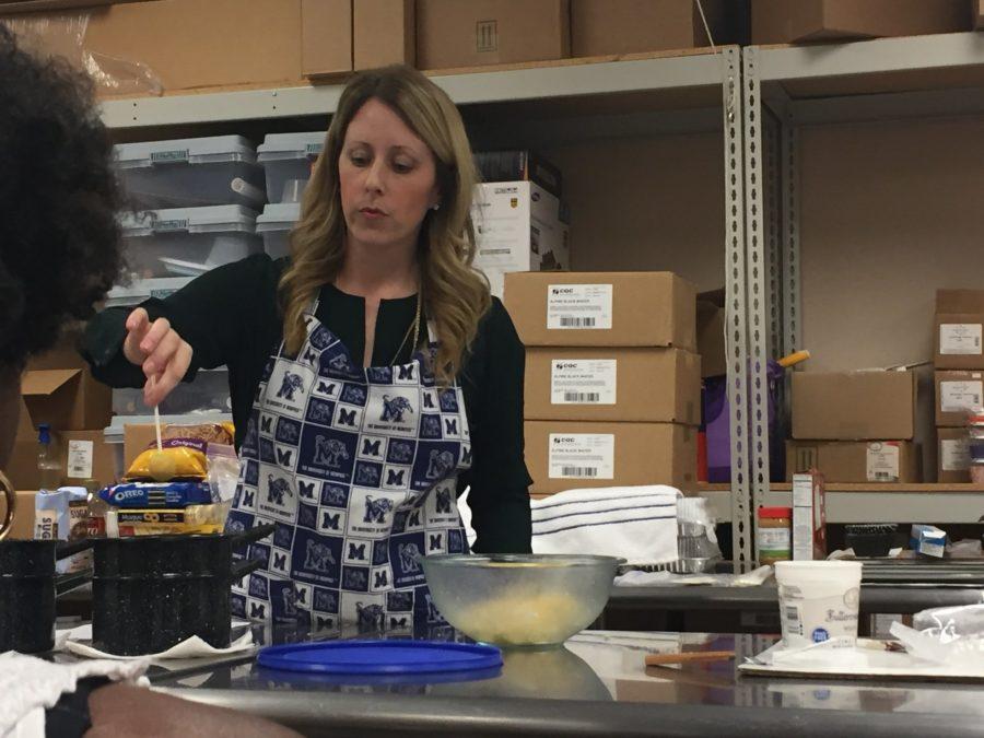 Ms. Faherty teaches the class how to correctly cover the cake pops in chocolate. She pre-made the chocolate and shared tips with students on how to make it. Using a double boiler to melt the chocolate as well as only melting a half pound at a time were recommended. 