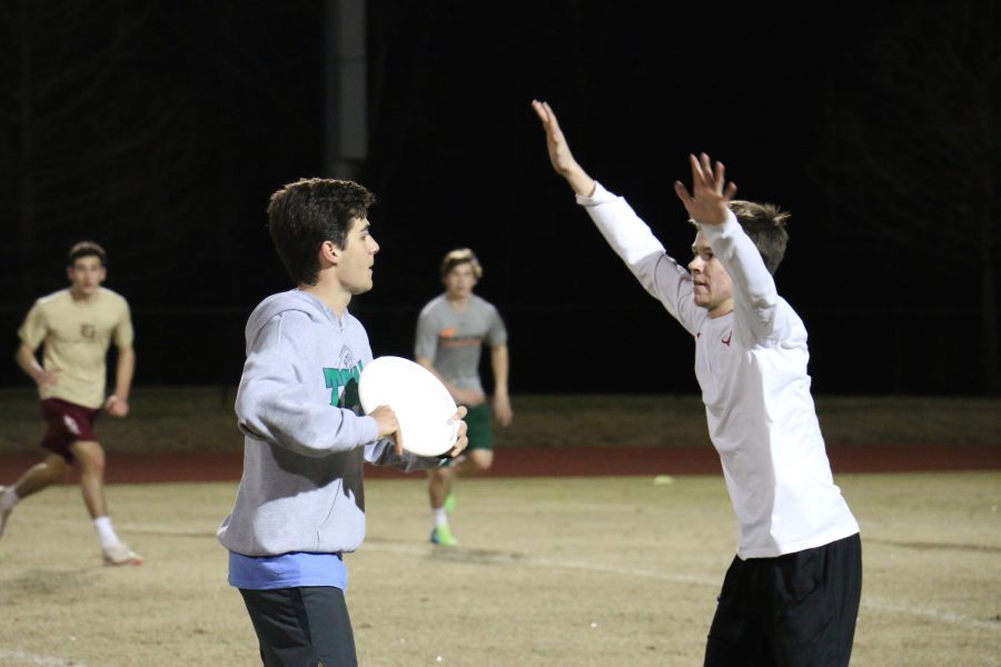 Junior Dalton Reese guards Ultimate Club president Winston Margaritis as he looks to throw downfield. The Ultimate Club held a game in the football stadium on Feb. 16. 
