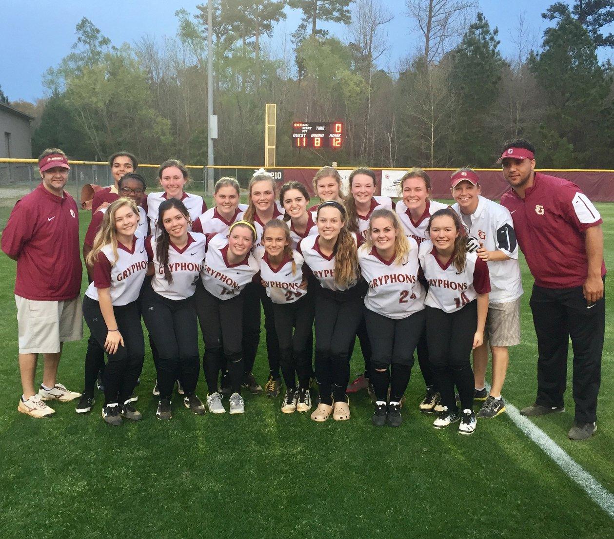 The softball team poses in front of the scoreboard after winning their game against the St. Agnes Stars. The 12-11 win was their first win of the season.