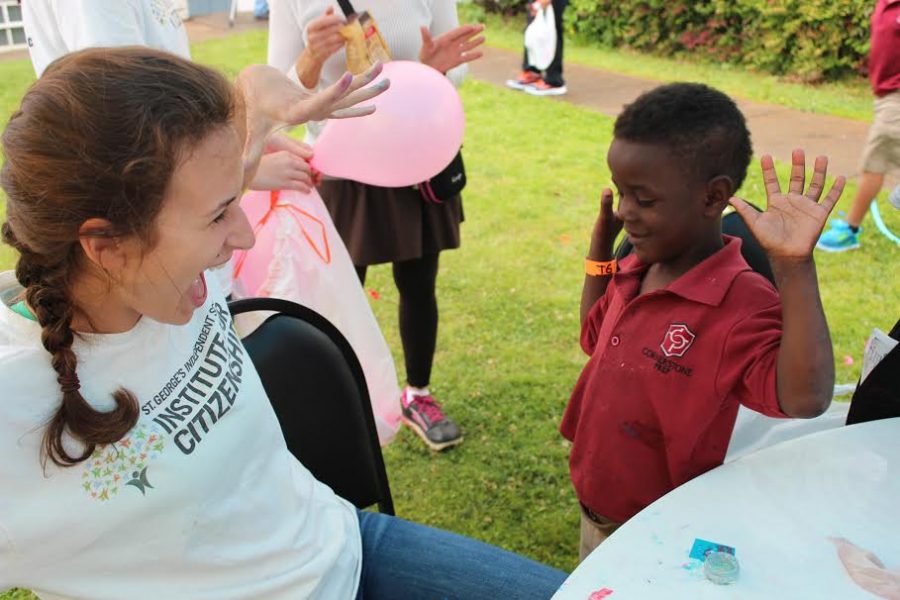 Senior Grace Optican gives a boy an exploding fist bump. The Citizenship Institute spent time serving  on Tuesday, April 11. 