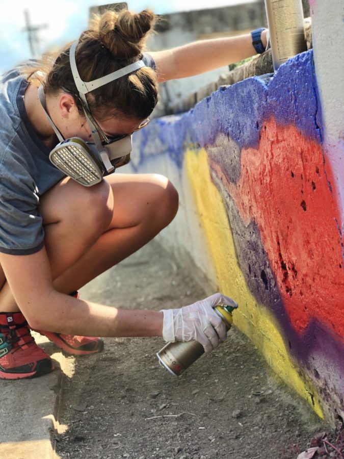 Senior Alice Crenshaw spray paints part of the St. George’s mural at Altown Skatepark. Many students stepped up in the process of creating the mural.
