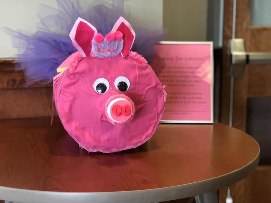 A Coins for Carson jar sits by the front desk of the Collierville campus. Head chose pink and purple piggy banks because they were her favorite colors. 