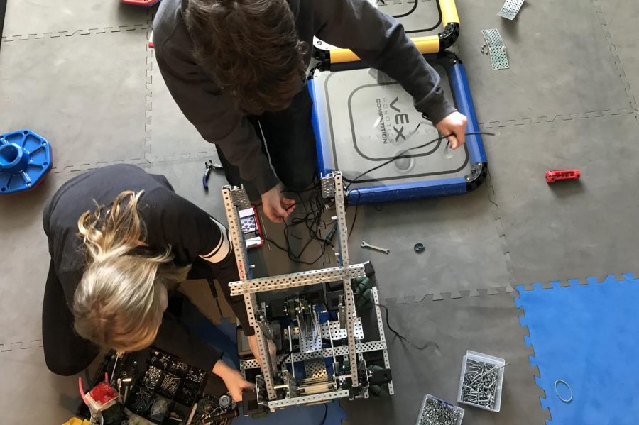 Junior Elizabeth Crane and Sophomore Kagan Sears prepare reconfigure their robot. They practiced on the field to prepare for the upcoming competition.