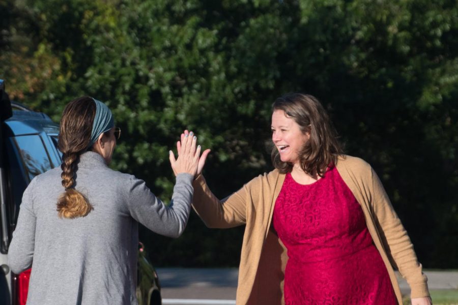 Ms. McCarthy high-fives a mom on High-Five Friday. Ms. McCarthy started the tradition with the intent to give students and families a boost of confidence to start the day.