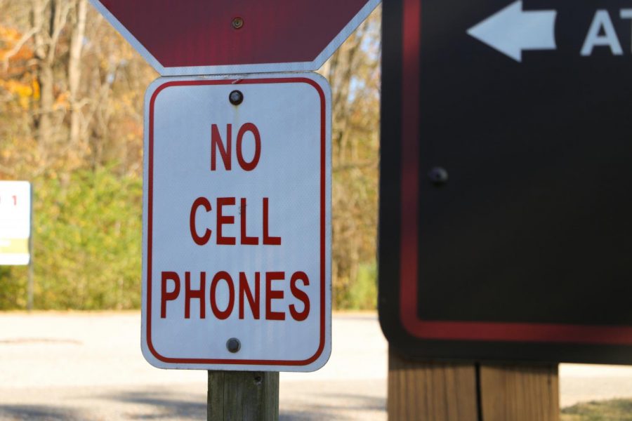 A No Cell Phones sign sits underneath the stop sign at the Houston Levee entrance to St. Georges. Since August, students have been using their cell phones to fill out a health survey before school. 