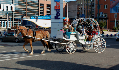 A carriage full of people drives across a street in front of the FedEx Forum. Carriage rides were one of several downtown attractions that have reopened.