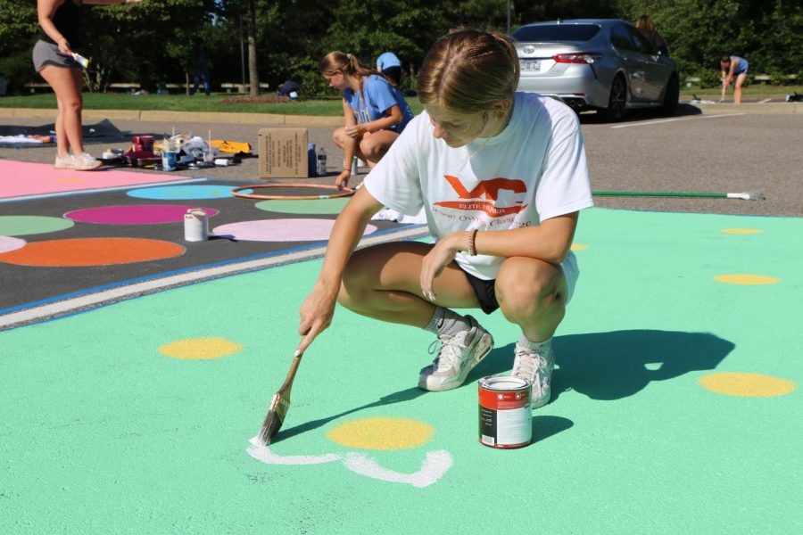 Lauren+Rutlin+paints+flowers+onto+her+senior+parking+spots.+Seniors+have+the+option+to+reflect+their+creativity+into+their+work.+