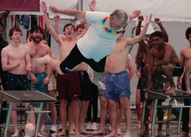 Coach David Stooksbury belly flops
into the pool as senior students cheer
him on.