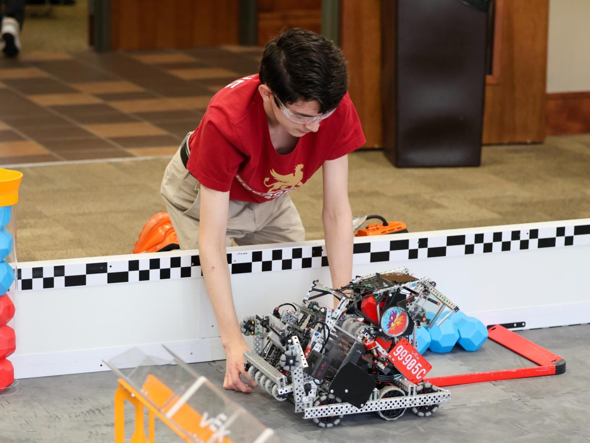 Senior Kade Reavis analyzes his team's robot during the Love at First Bot robotics competition at the St. George's Middle and Upper School Campus on Saturday, Feb. 14.