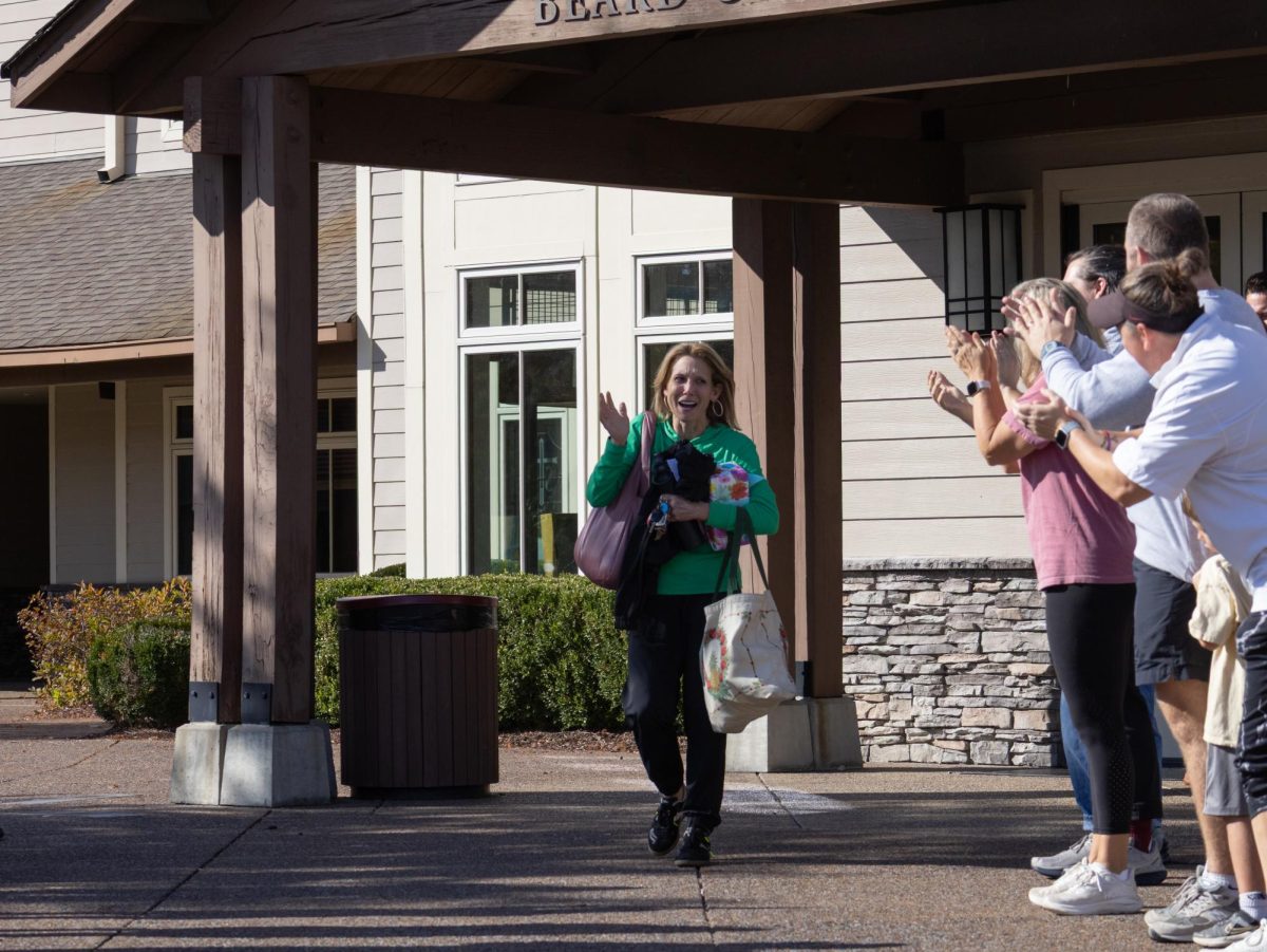 Mrs. Taylor walks out of the front door past her colleagues on her final day.